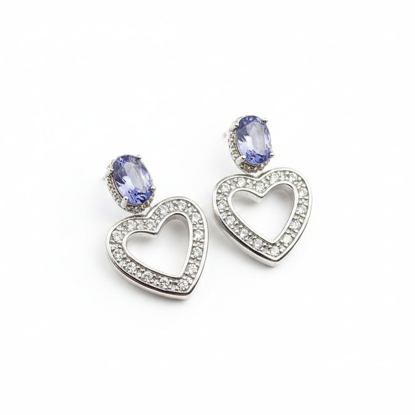 Heart-shaped earrings with Tanzanite stones on a black velvet background