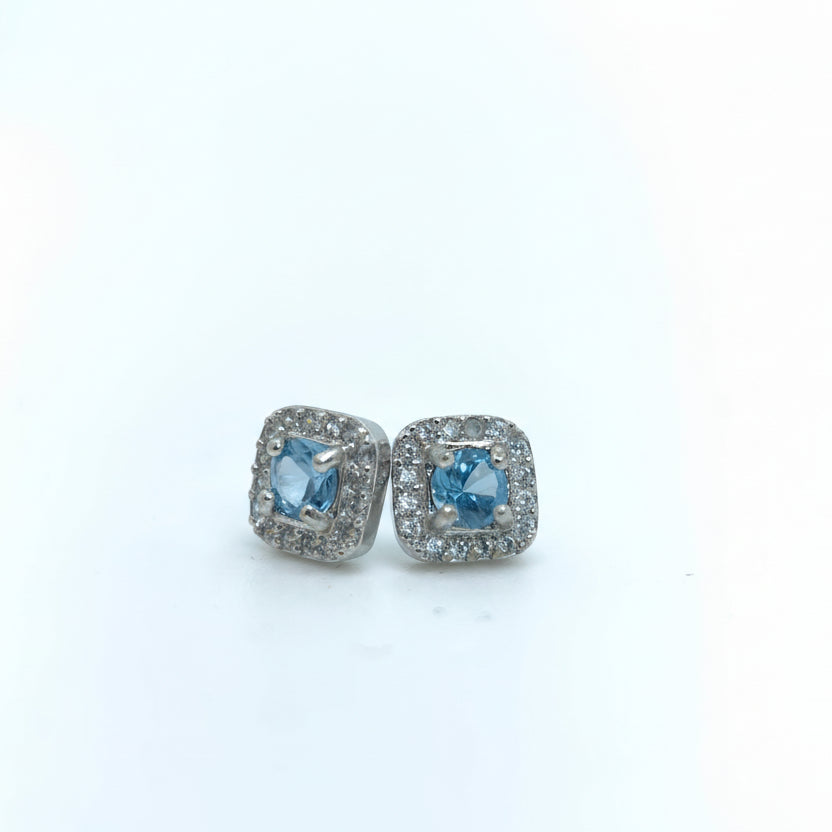 Pair of earrings with blue gemstones on a light gray background