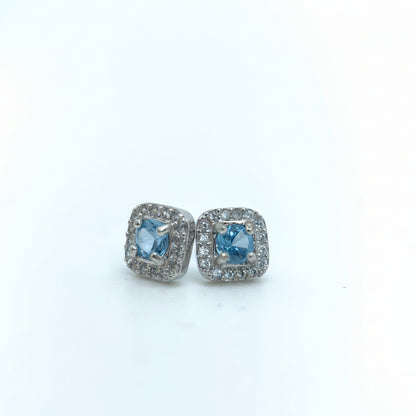 Pair of earrings with blue gemstones on a light gray background