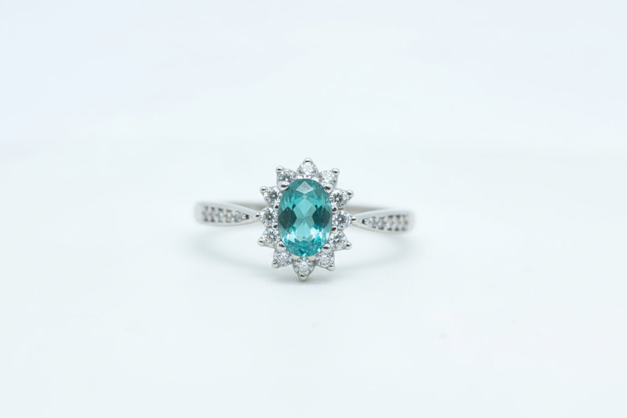 Gold ring with a green gemstone on a light gray background
